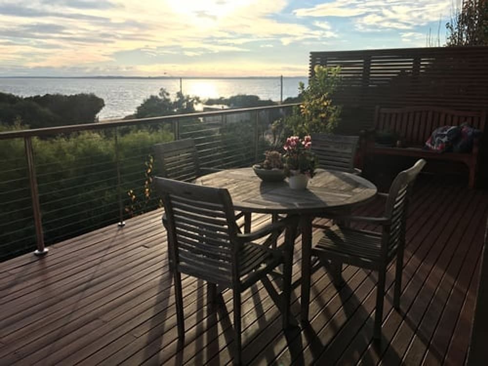 Finished wood deck with railing and outdoor seating built by G&I B Construction